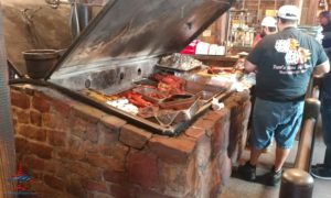 a man standing next to a large grill