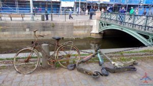 a bike and scooter on the side of a river