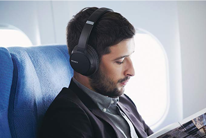 Airline flight passenger wearing Sony WH-CH700N Wireless Bluetooth Noise Canceling Over the Ear Headphones with Alexa Voice Control – Black