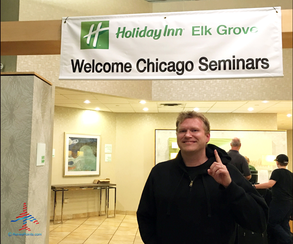 Rene's Points owner-editor-writer Chris Carley poses under the Chicago Seminars banner at the Holiday Inn Chicago-Elk Grove Village.