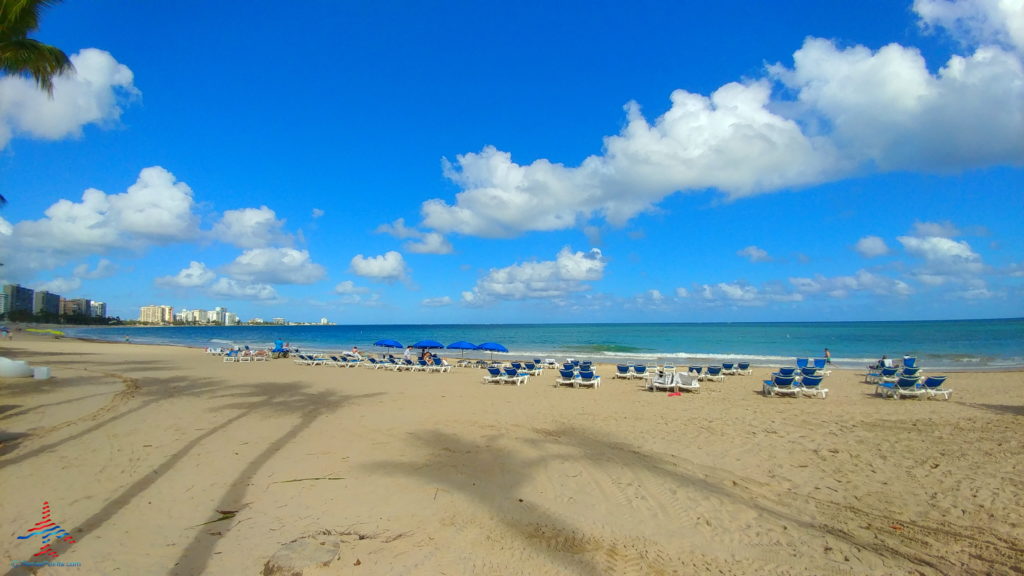 a beach with chairs and umbrellas