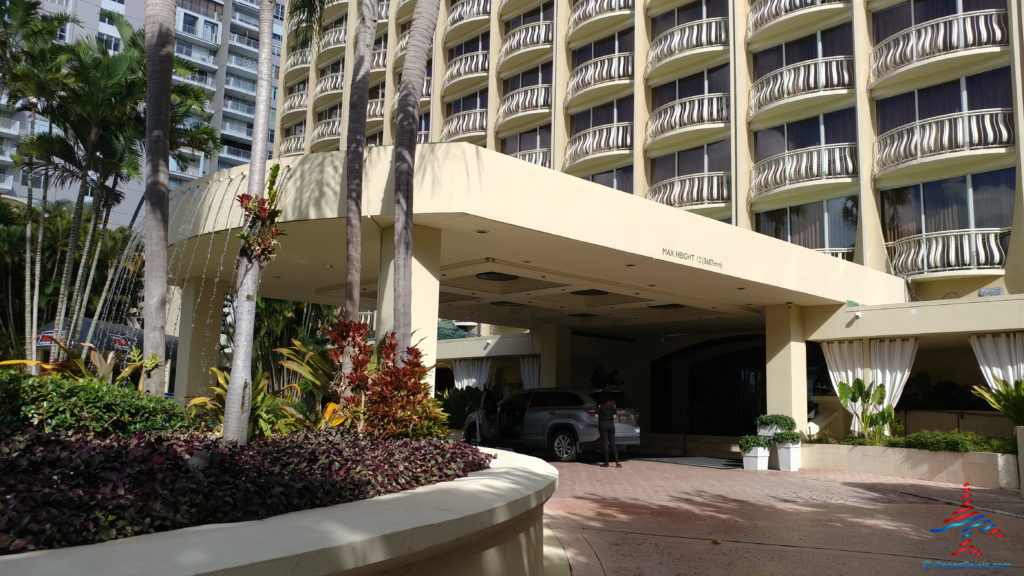 a building with a parking lot and palm trees