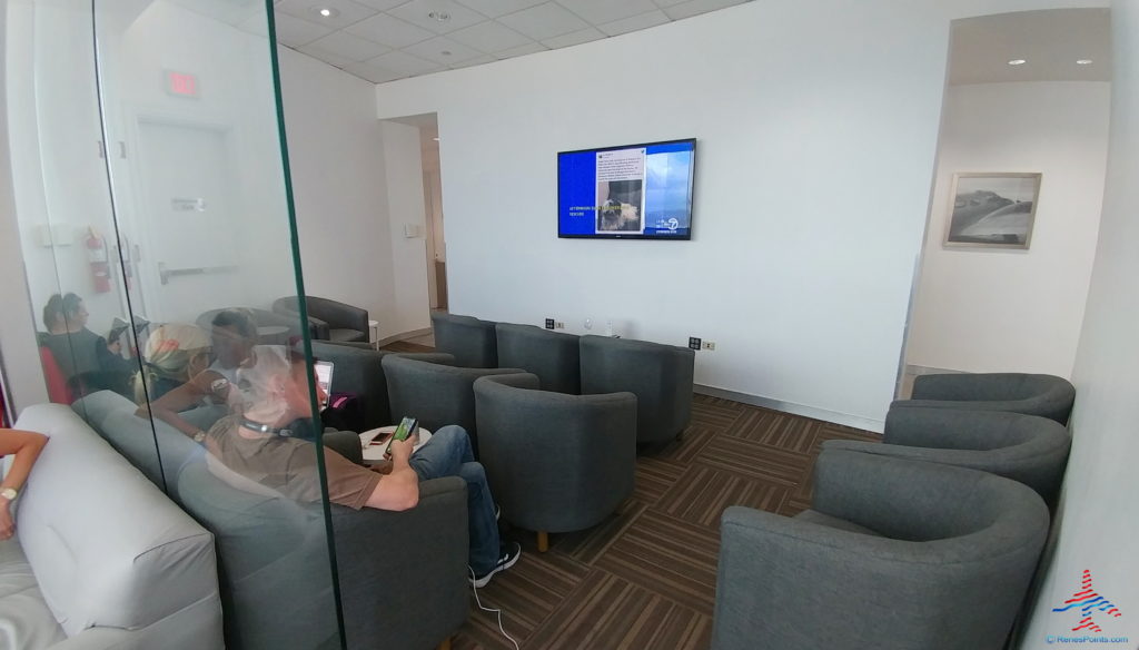 a group of people sitting in chairs in a room with a television