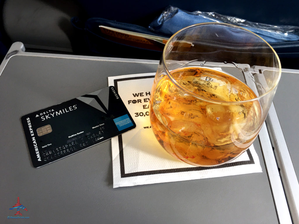 A Delta Reserve for Business American Express credit card is seen next to a glass of Woodford Reserve bourbon on a Delta Connection flight operated by SkyWest Airlines.