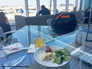 Bourbon and salad with chicken and cheese are seen at the United Club LAX airport lounge in Los Angeles, California. © Chris Carley / PointsLounge