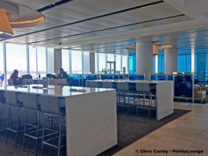 A seating area with high tables is seen at the United Club LAX airport lounge in Los Angeles, California. © Chris Carley / PointsLounge.