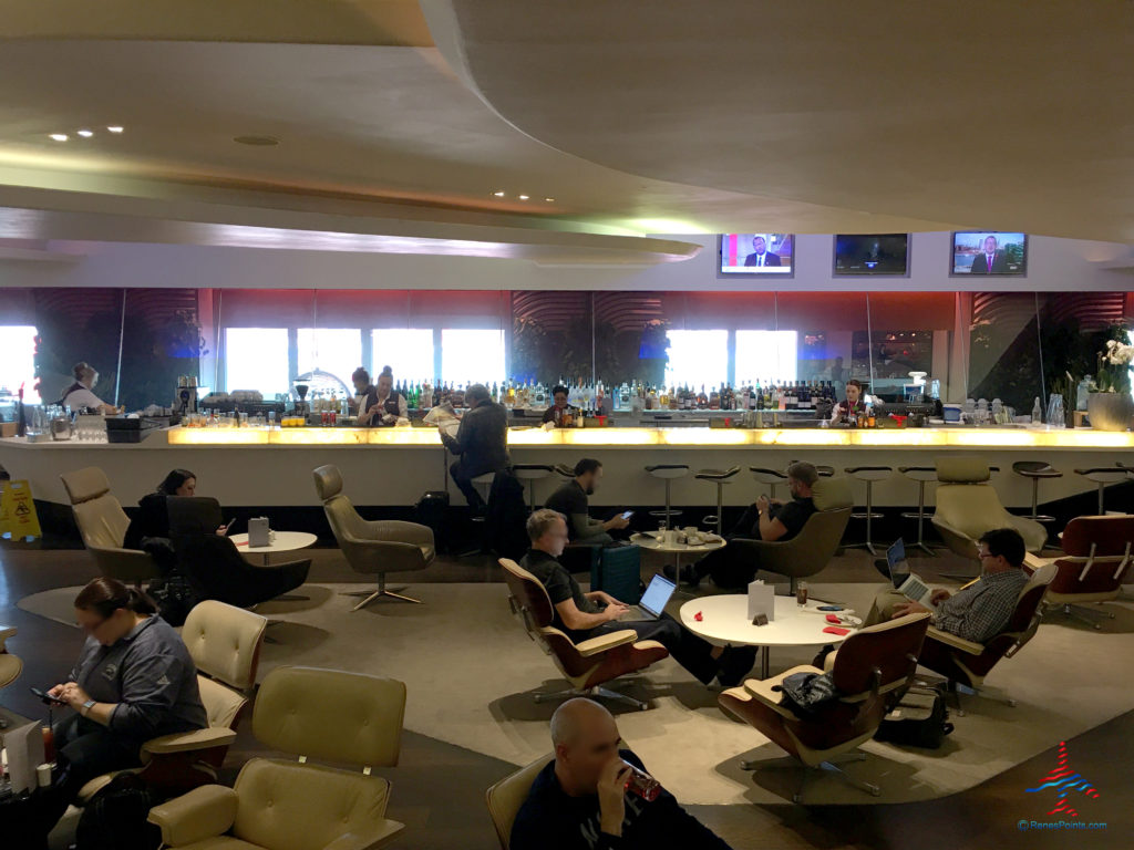 The bar and adjacent seating area are seen inside the Virgin Atlantic Clubhouse airport lounge at London Heathrow Airport (LHR).