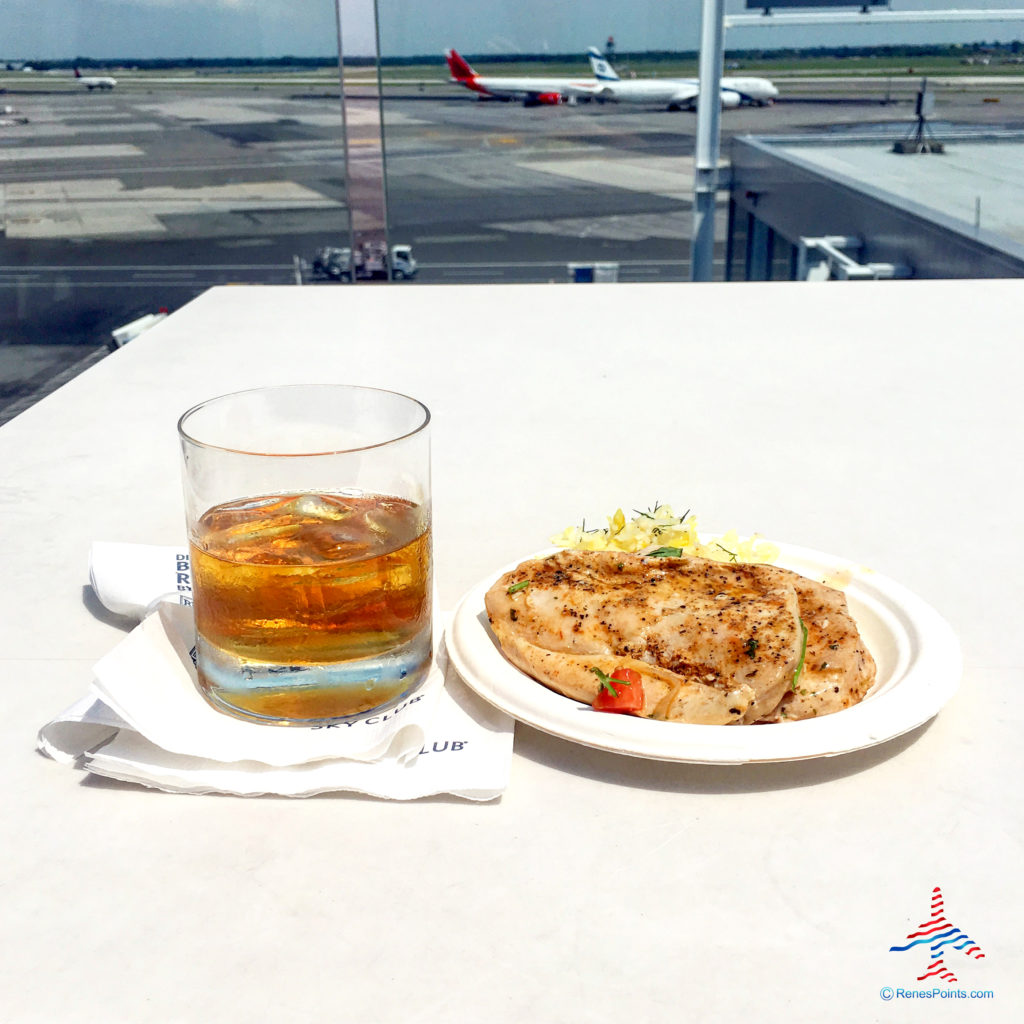 A glass of Booker's bourbon whiskey and plate of chicken with rice are seen on the Sky Deck of Delta Air Lines' Delta Sky Club at New York's Kennedy Airport (JFK).