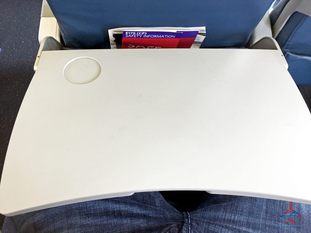 A Delta Air Lines Connection Compass Airlines Embraer 175 empty tray table.