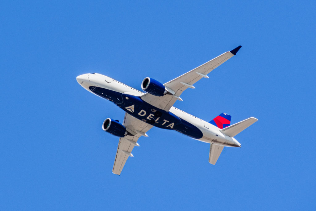 August 1, 2019 Santa Clara / CA / USA - Delta Airlines aircraft in flight; the Delta Logo visible on the airplanes' underbelly; blue sky background