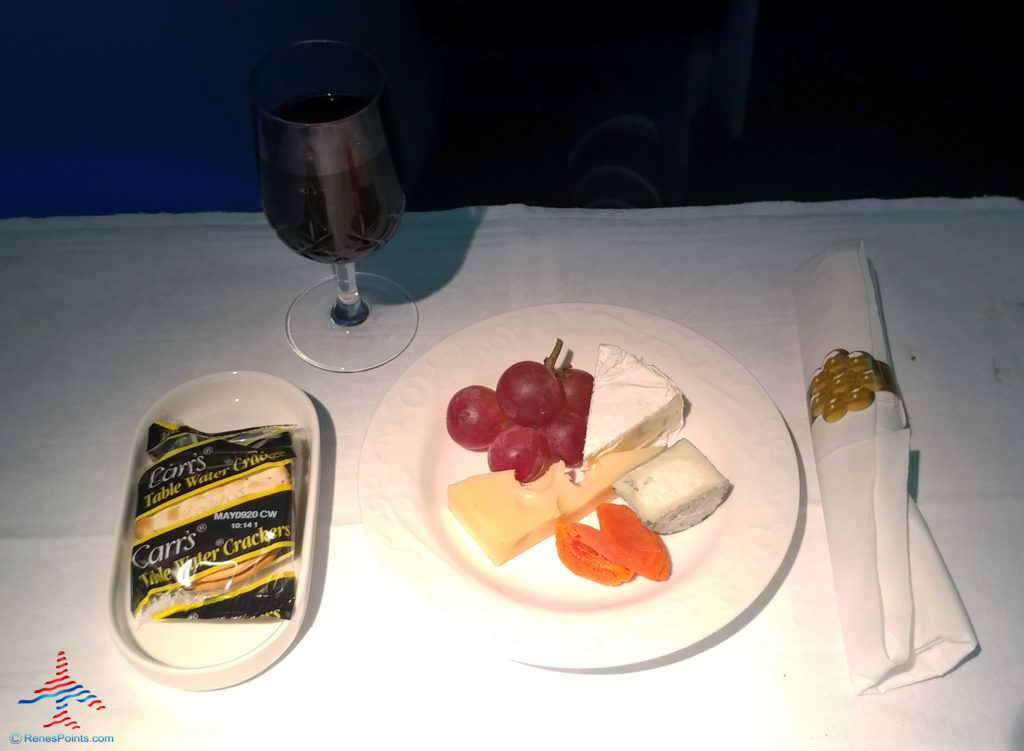 a plate of cheese and grapes on a table