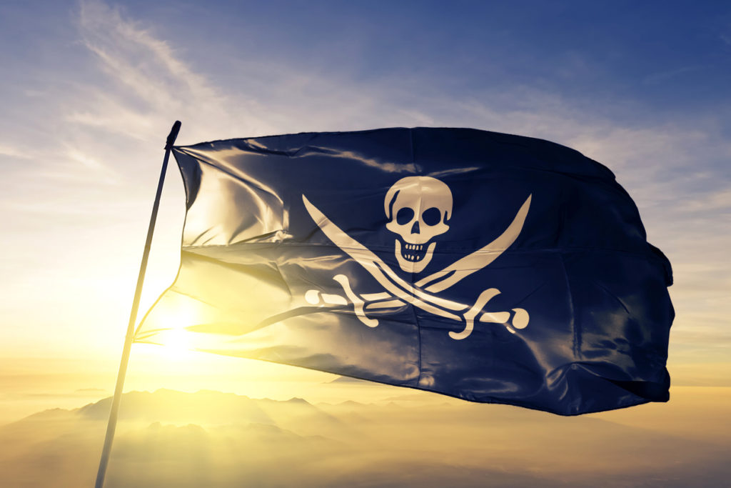 Pirate Flag flag on flagpole textile cloth fabric waving on the top sunrise mist fog
