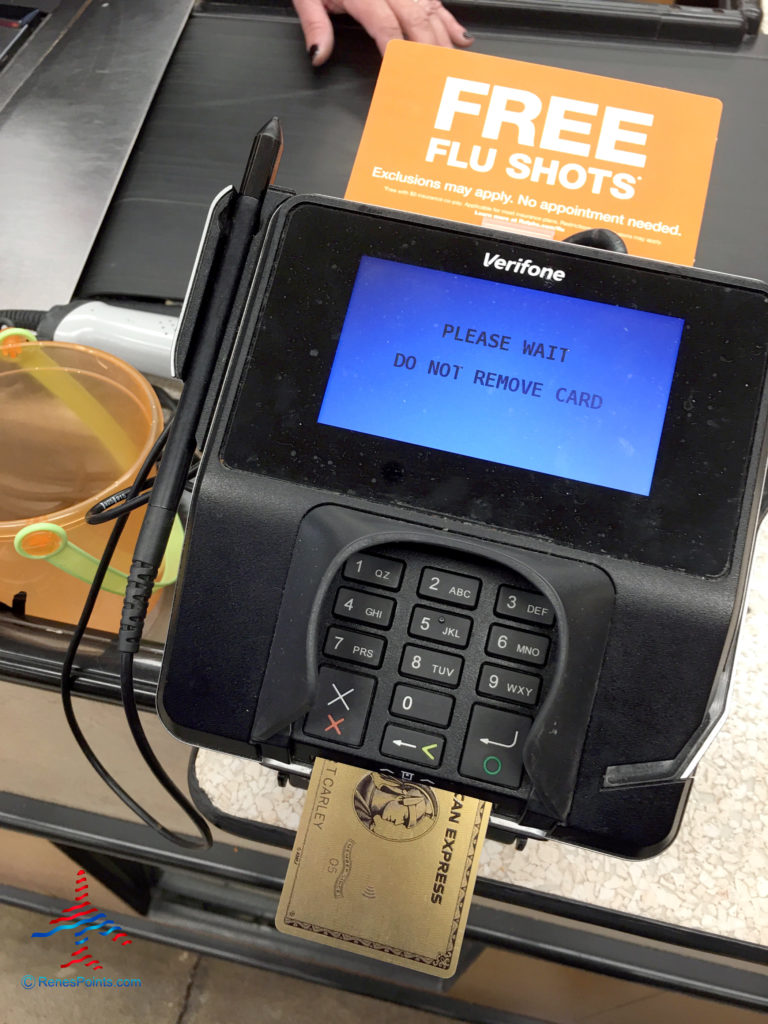 An American Express® Gold Card pays for groceries at a Ralphs supermarket in Los Angeles, California. The payment machine also advertises flu shots.
