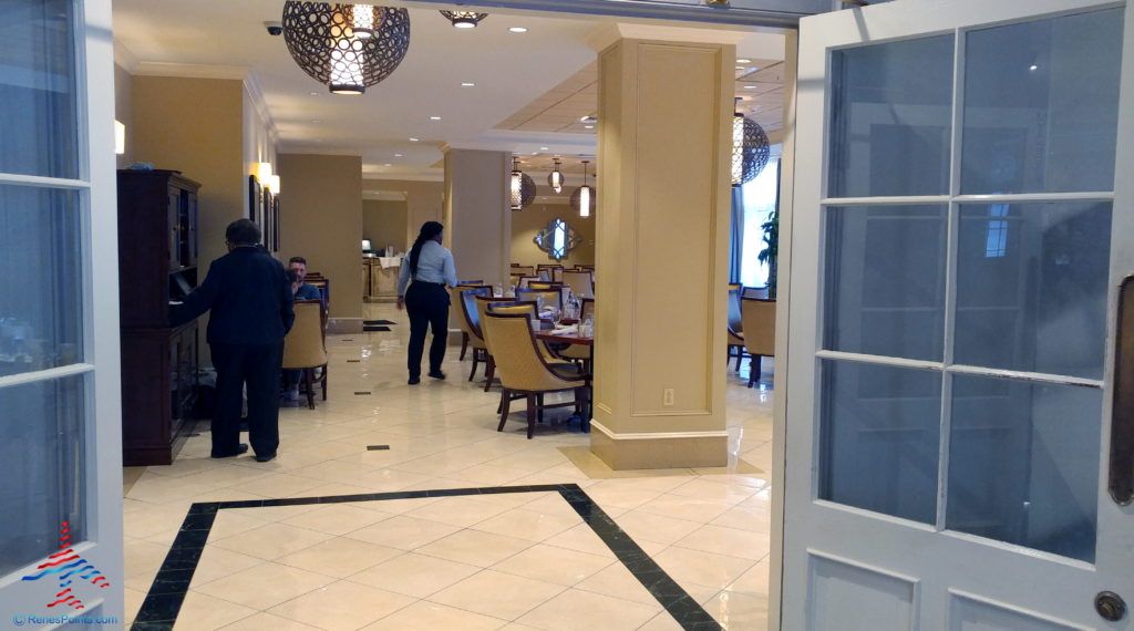 a room with a large white column and a couple of people standing in front of it