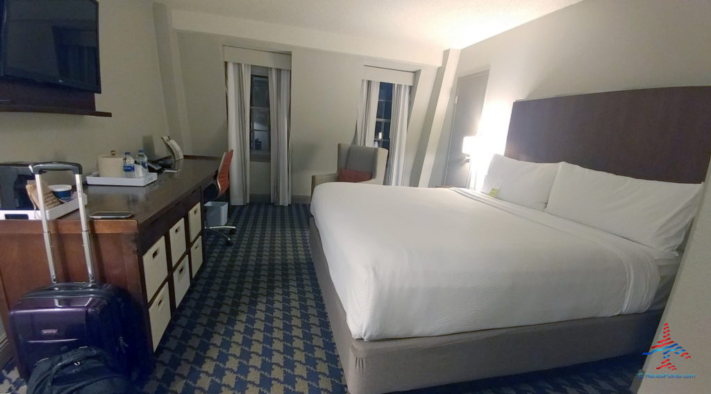 a hotel room with a bed and desk