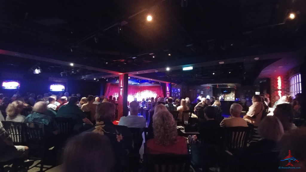 a group of people sitting in chairs in a room with a stage