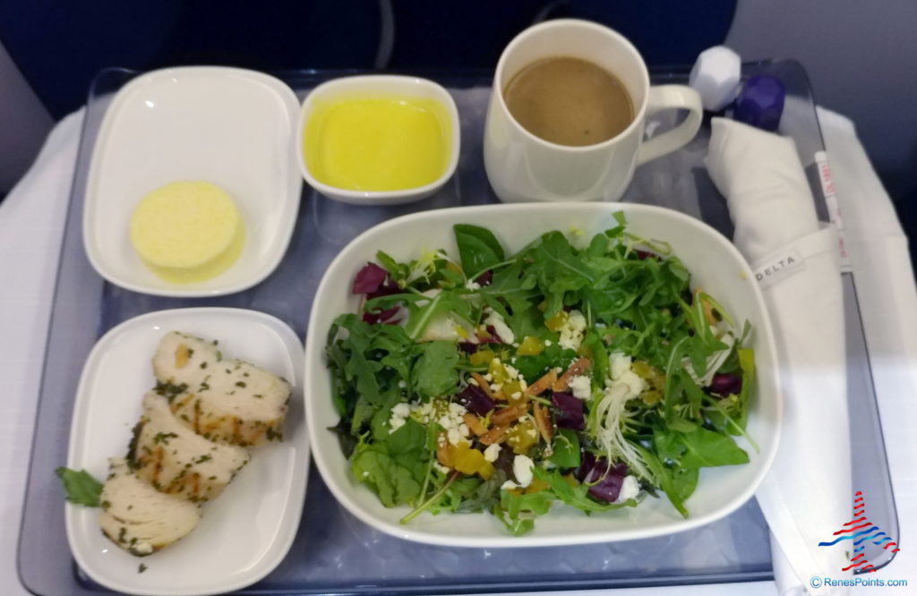 a plate of salad and two cups of coffee