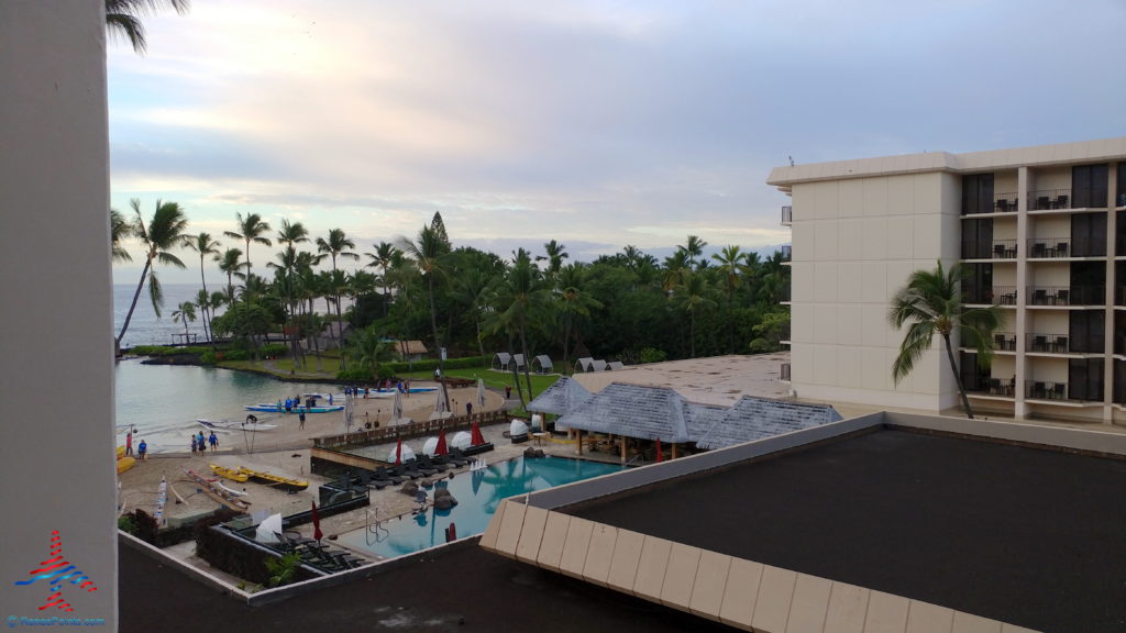 a pool and a building with trees and a body of water