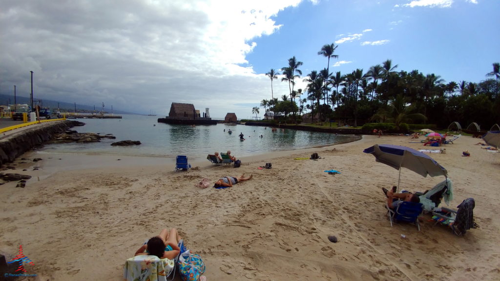 people on a beach with people in chairs and a body of water