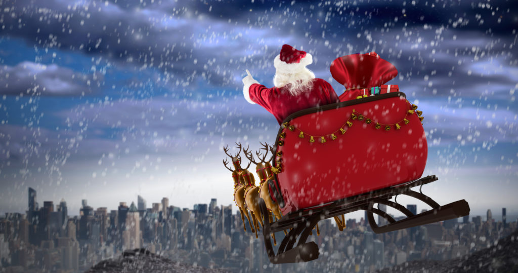 Santa Claus riding on sled against large city