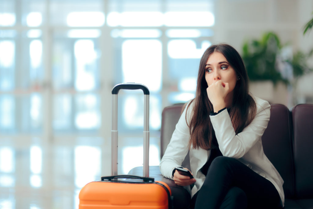 A worried traveler waits in an airport.