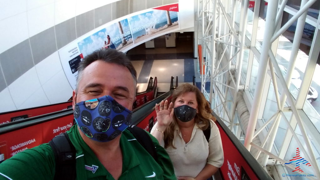 a man and woman on escalator wearing face masks