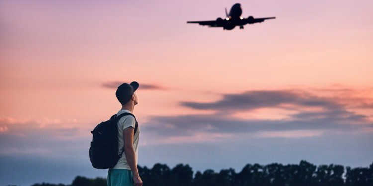 Traveler is looking at the landing airplane