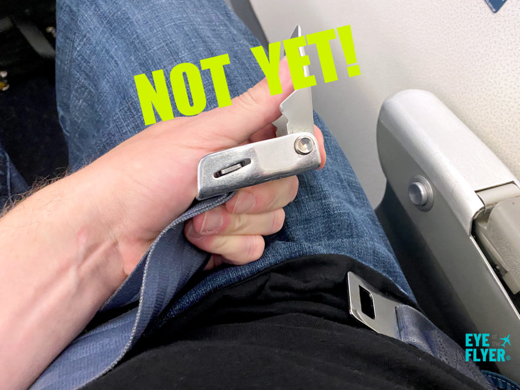 A passenger unbuckles a seatbelt on an airline flight.