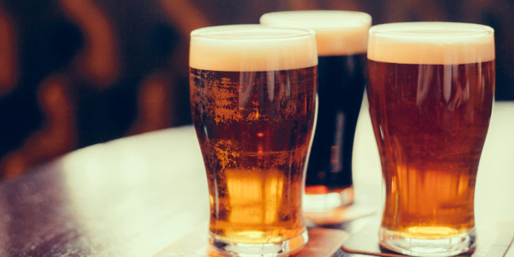 Glasses of light and dark beer on a pub background.