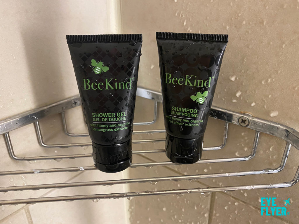 Bee Kind toiletries provided in the shower in bathroom inside a King Premier Room at the Kimpton Muse Hotel near Times Square in New York