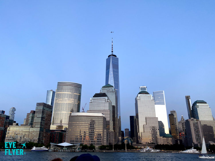 A Delta Air Lines plane flies over One World Trade Center at night during a Circle Line Harbor Lights Cruise.