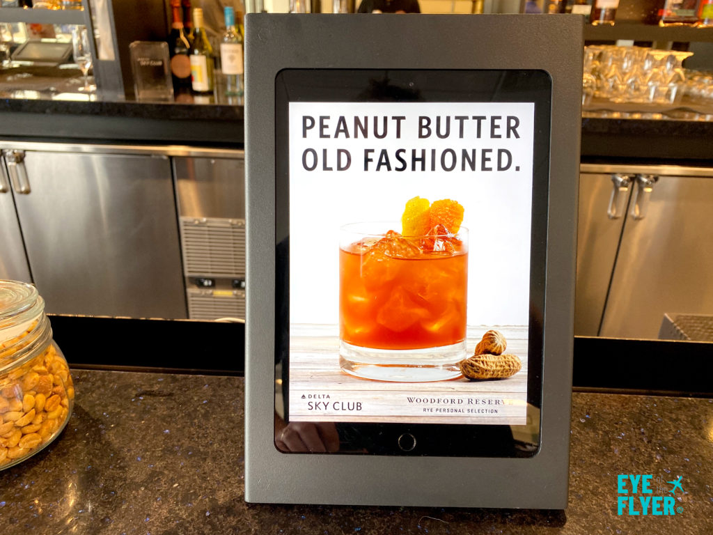 An advertisement for a Peanut Butter Old Fashioned inside the Newark (EWR) Delta Sky Club.