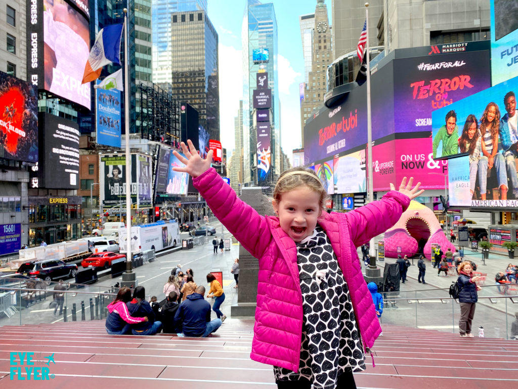 A little girl poses in New York City's Times Square Father Duffy Square. 