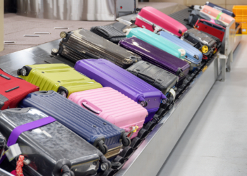 Bright suitcases on luggage conveyor belt in airport