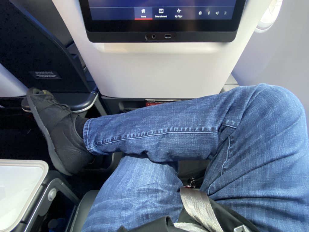 a person's legs in a seat on an airplane