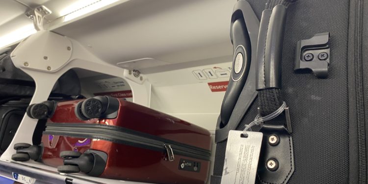 luggage on a shelf in an airplane