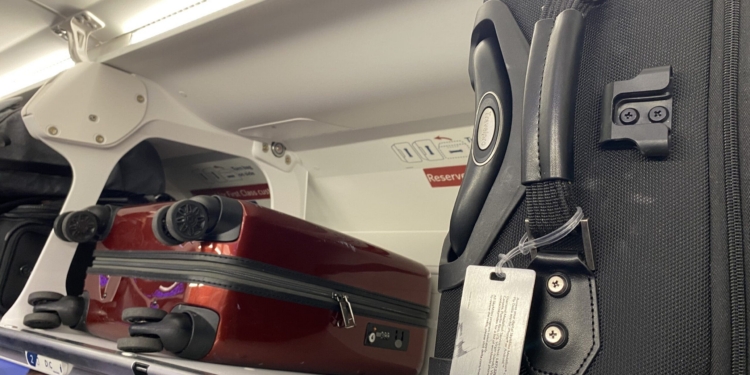 luggage on a shelf in an airplane