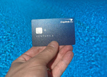 The Capital One Venture X Rewards Credit Card set against a swimming pool.