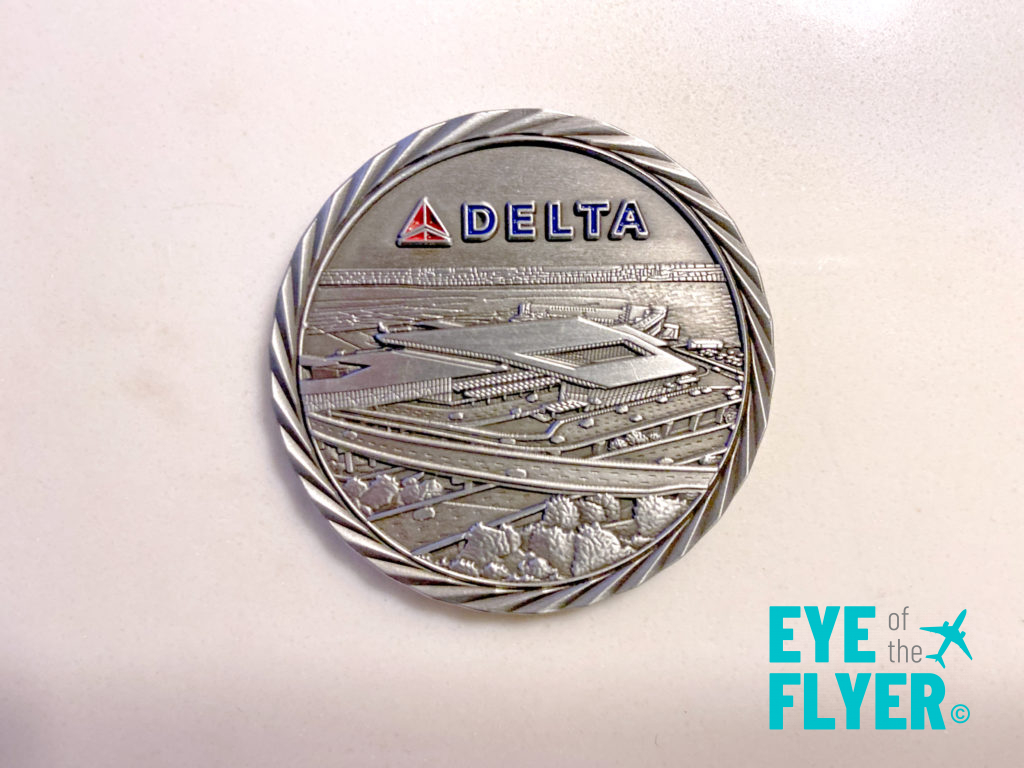 a silver coin with a picture of a runway and a plane