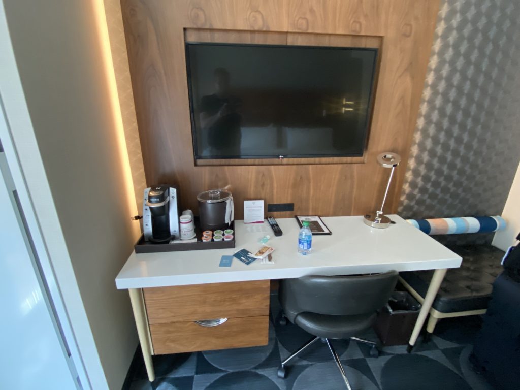 a desk with a tv on the wall