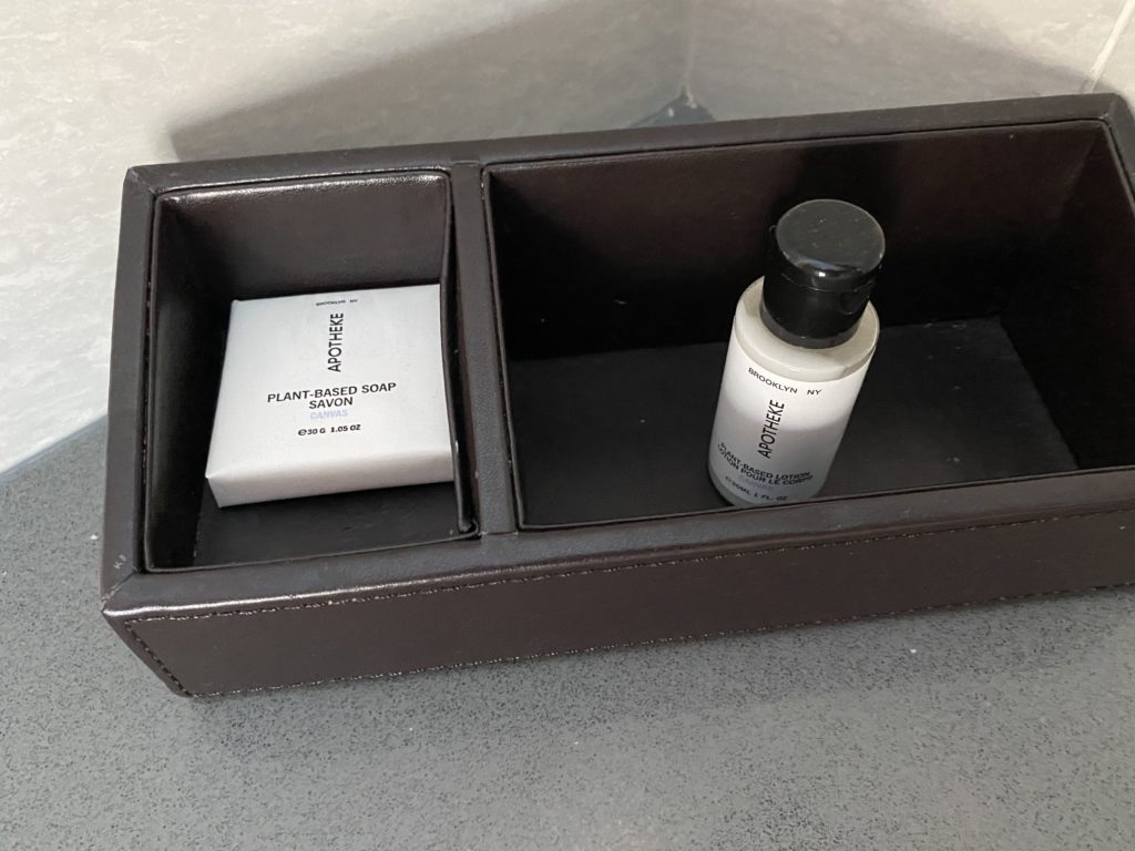 a black box with a small white bottle and a white box with a black lid