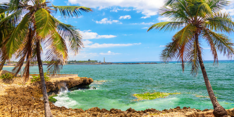 Beautiful coast with palms in Santo Domingo, Dominican Republic. Caribbean sea with lighthouse