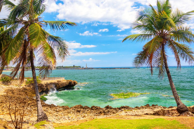 Beautiful coast with palms in Santo Domingo, Dominican Republic. Caribbean sea with lighthouse
