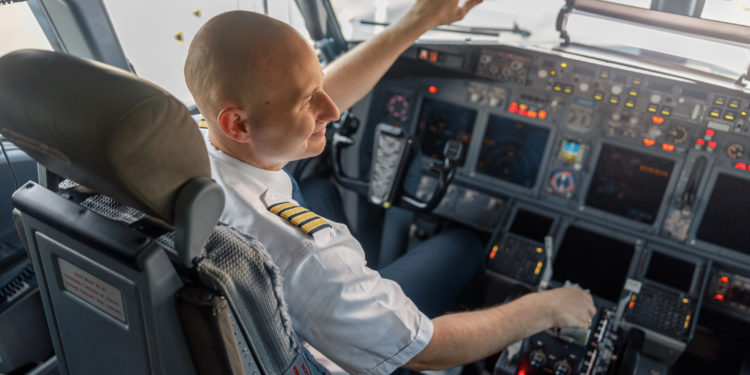 An airline pilot sits in the cockpit