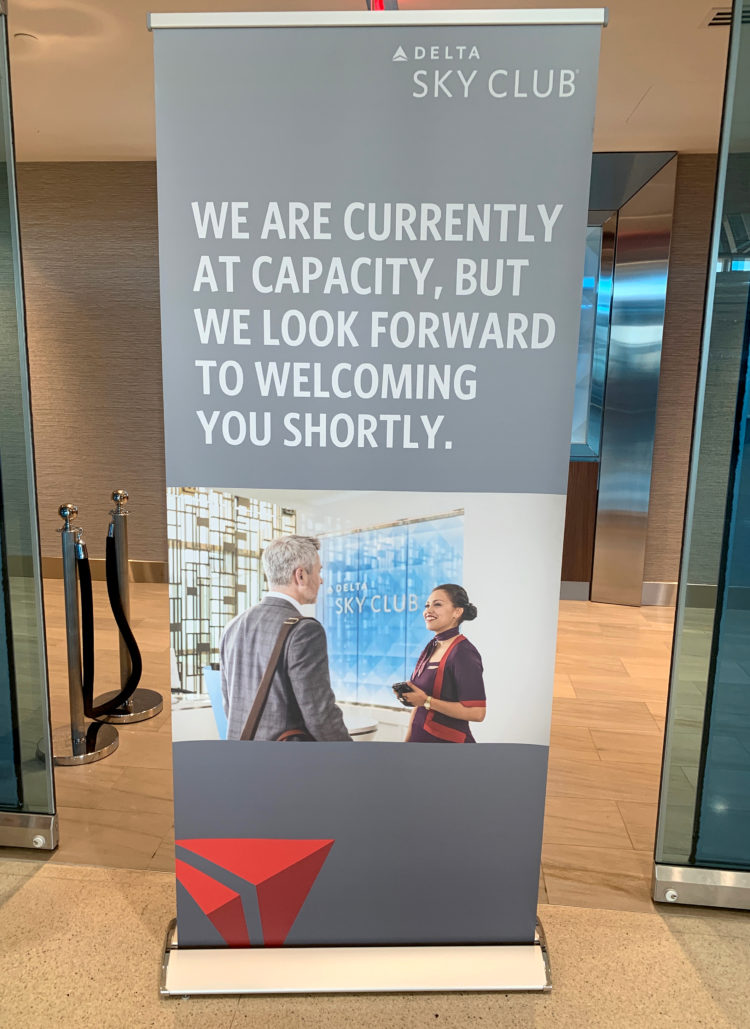 A Delta Sky Club airport lounge in Detroit displays a sign telling guests that the location is at capacity.
