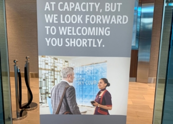 A Delta Sky Club airport lounge in Detroit displays a sign telling guests that the location is at capacity.