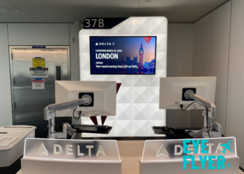 a room with white chairs and a large screen