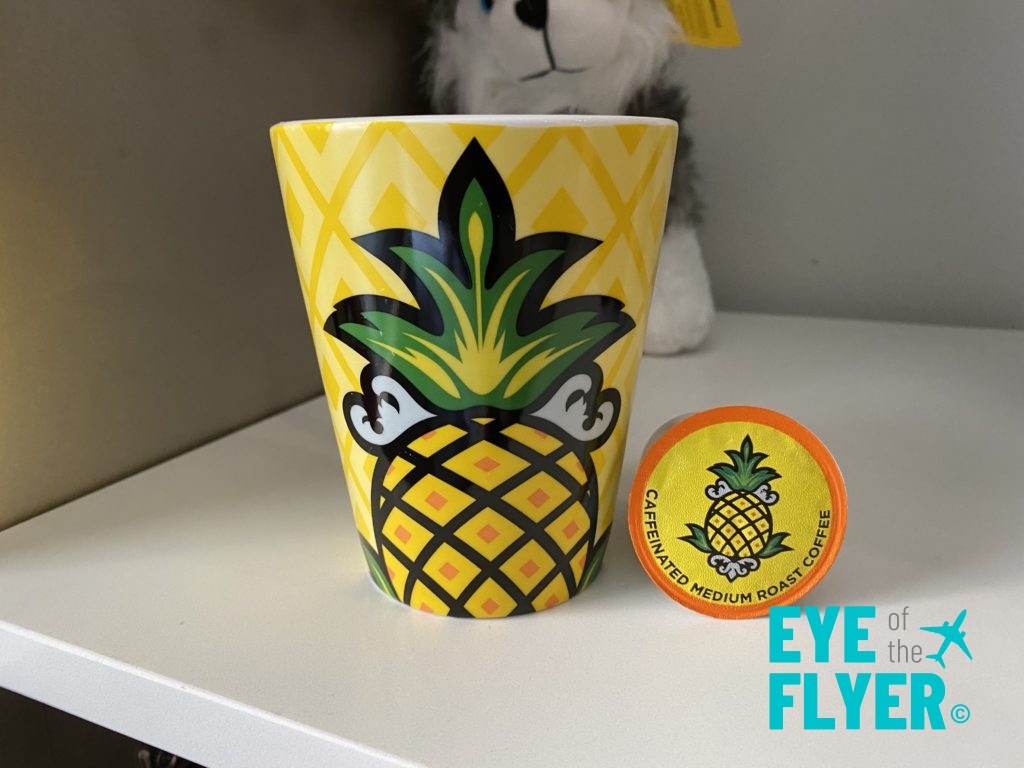 a yellow mug with pineapple design and a yellow lid