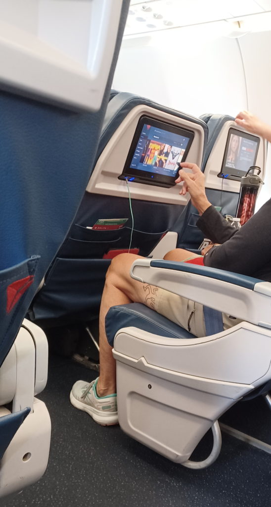 a person sitting in an airplane with a tablet