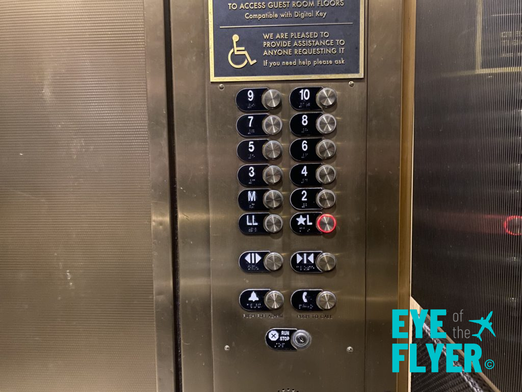a elevator panel with buttons and a sign